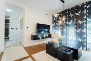 a living room with a black table and a tv at Liberty Central Apartment in Tuzla