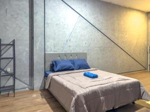 a bedroom with a bed with blue pillows on it at Kamar Pluit Karang in Jakarta