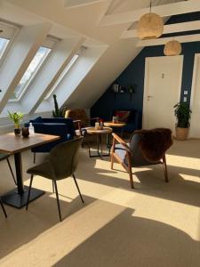 a room with tables and chairs in an attic at Villa Søholt - Silkeborg Bed and Breakfast in Silkeborg