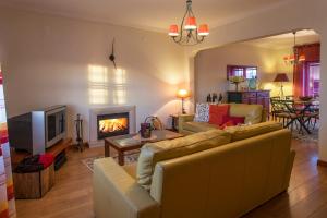 - un salon avec un canapé et une cheminée dans l'établissement Casa da Póvoa, à Mafra