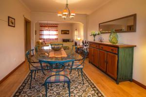 uma sala de jantar com uma mesa de vidro e cadeiras em Casa da Póvoa em Mafra