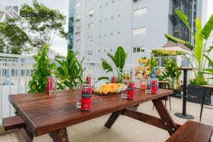 a wooden table with soda cans and a plate of food at Cubicity Ton That Tung in Ho Chi Minh City
