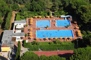 una vista aerea di un resort con 2 piscine e ombrelloni di Baia Toscana a Piombino
