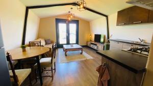 a kitchen and living room with a table and a dining room at Family holiday home by beach and forest in Dirkshorn