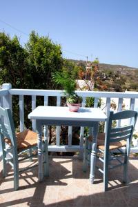 Thea House Patmos في Kámbos: طاولة بيضاء و كرسيين على فناء