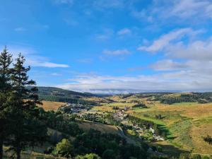 a view of a valley with a town on a hill at La Bastide en Margeride in Châteauneuf-de-Randon