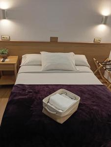a large bed with an open suitcase on it at Hotel Carabela La Pinta in Baiona