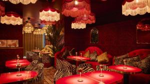 a restaurant with red tables and zebra chairs and chandeliers at Solo Sokos Hotel Turun Seurahuone in Turku
