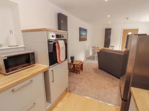 a kitchen with a refrigerator and a living room at Little Plumtree in Milnthorpe