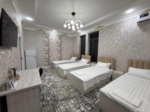 a room with four beds and a sink in it at Golden Emir Residence in Bukhara