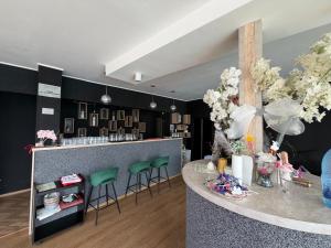 a bar with green stools and a counter with flowers at Hypnotic Villa Pitesti in Piteşti