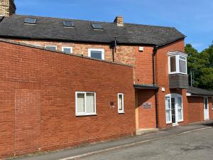 a red brick building with white windows on a street at The Flat House in Taunton