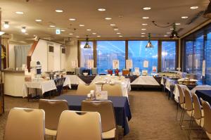 a banquet hall with tables and chairs with a view at Hotel Sunroute Aomori in Aomori