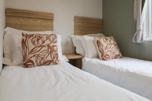 two beds sitting next to each other in a bedroom at Jurassic Discovery in Charmouth +22 photos