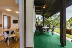 a room with a green carpeted floor and a table and chairs at Alp Pension in Bled