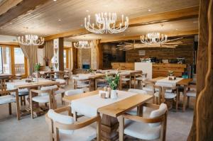 a restaurant with tables and chairs and chandeliers at Prispa Premium Resort in Vişeu de Sus