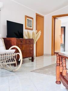 a living room with a tv and a chair and a dresser at Villa Artemide - Ospitalità nel Borgo in Marsico Vetere