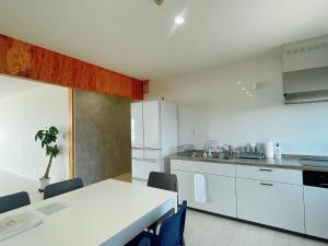 a kitchen with white cabinets and a table and chairs at HOJO Brewing & Stays in Hōjō +32 photos