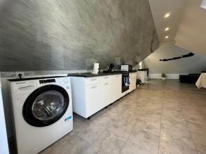 a laundry room with a washing machine and a counter at Garda Apartman in Balatonfenyves