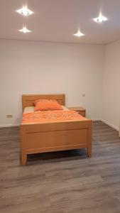 a bedroom with a bed with an orange comforter at Haus Linde in Wengenroth +4 photos