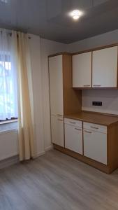 an empty room with white cabinets and a window at Haus Linde in Wengenroth
