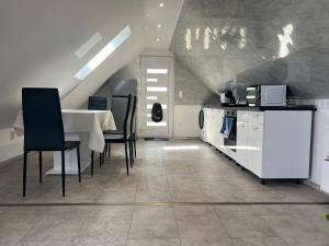 a dining room with a table and chairs and a kitchen at Garda Apartman in Balatonfenyves