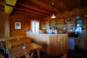 a man and woman standing at a bar in a cabin at Glatzl Trahütten Alm in Sankt Lorenzen am Wechsel
