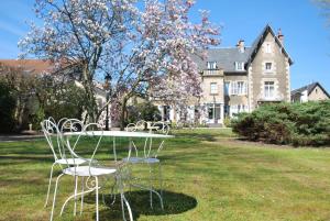 two chairs and a table in front of a house at Le Clos De Bourgogne in Moulins