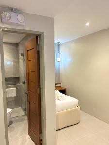 a bedroom with a bed and a bathroom with a shower at Olive's Suites in Kalibo +27 photos