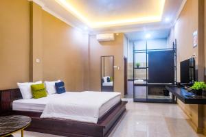 a bedroom with a bed and a flat screen tv at Urbanview TWH Costel near Stadion Maguwoharjo Yogyakarta in Yogyakarta