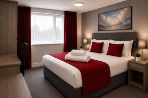 a hotel room with a large bed with red pillows at Saram Lodge Dudley in Dudley