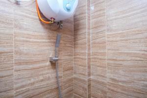 a shower with a hose attached to a wooden wall at Urbanview TWH Costel near Stadion Maguwoharjo Yogyakarta in Yogyakarta +55 photos