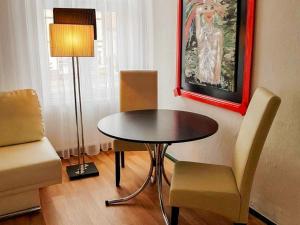 a dining room with a table and chairs and a painting at City Urlaub in Ribnitz-Damgarten +10 photos