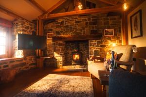 a living room with a stone fireplace and a chair at Mullach Dearg in Tarbert