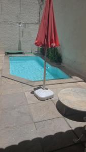 a red umbrella sitting next to a swimming pool at Pousada Icaraí Inn in Niterói +44 photos