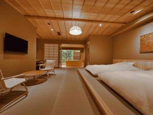 a bedroom with a bed and a table and chairs at Araya Totoan in Kaga