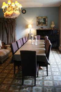 a dining room with a table and purple chairs at La Maison de Jeanne in Thiézac