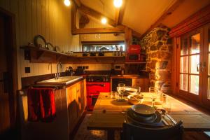 a kitchen with a red stove and a wooden table at Mullach Dearg in Tarbert
