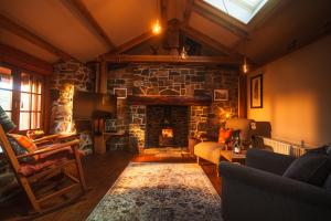 a living room with a stone fireplace with a tv at Mullach Dearg in Tarbert