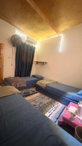 a room with three beds and a curtain at SafeZone Guesthouse in Dahab