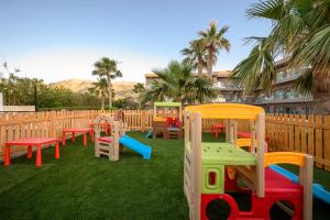a playground with colorful play equipment on the grass at Malia Bay Beach Hotel & Bungalows in Malia