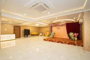 a room with a couch and a stage with flowers at Devbhoomi Inn in Deoghar