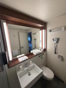 a bathroom with a sink and a mirror at Campanile Chambéry in Chambéry +19 photos