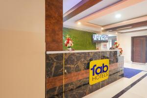 a lobby of a hotel with a sign on the wall at FabHotel Saanidhya Comforts - Tumkur Road in Kunigal