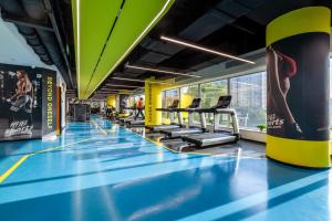 a gym with a blue floor and treadmills at Beijing Landmark Hotel in Beijing