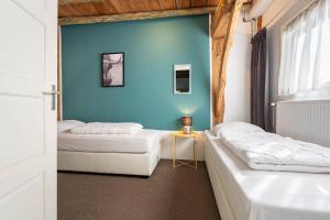 two beds in a room with a blue wall at De Toffe Peer Recreatie in Ruinerwold