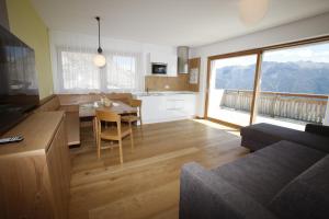 uma cozinha e sala de estar com uma mesa e um sofá em Innerunterstellhof em Naturno