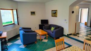 a living room with two blue chairs and a table at Andels apartments Vila 3 in Rynholec