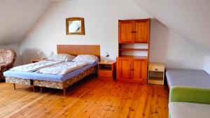 a bedroom with a bed and a wooden floor at Andels apartments Vila 3 in Rynholec