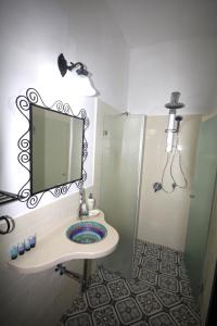 een badkamer met een wastafel, een spiegel en een douche bij Stav Bagolan in Ani'am